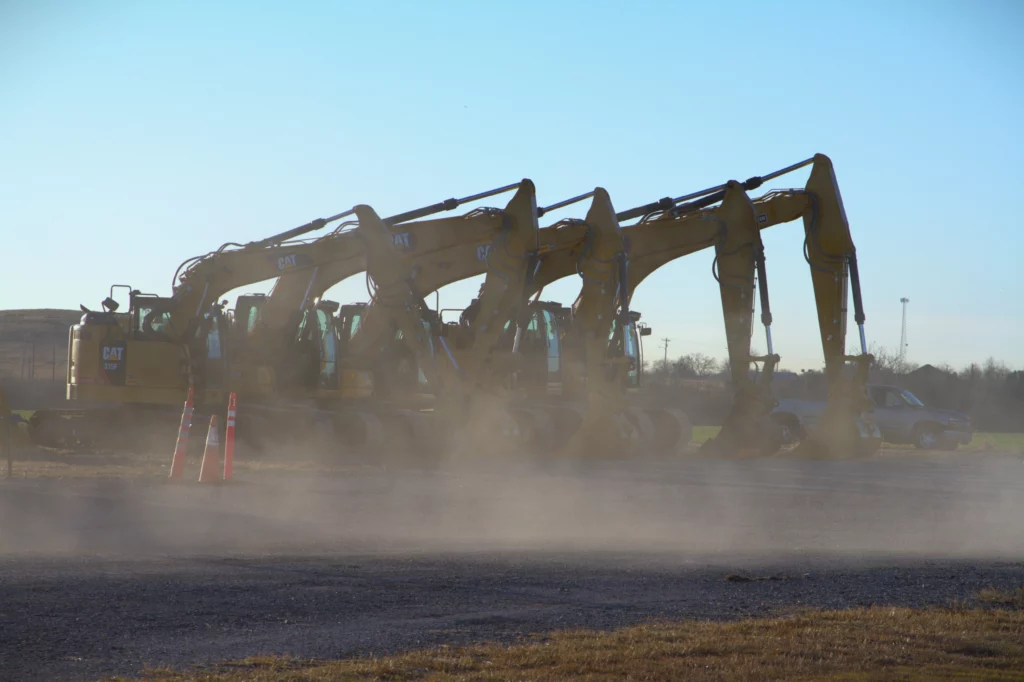 Fleet of excavators parked at Iron Ranch Equipment rental yard.